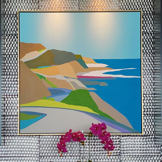 Decorative wall art of a coastal scene above a bar setup with flowers.
